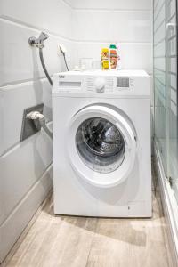 a white washing machine in a laundry room at CENTRAL & AFFORDABLE by JR City Apartments in Vienna