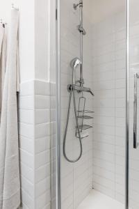un bagno con doccia e piastrelle bianche di ACQUARIO 5 Minuti, FREE A-C, Wifi & Netflix ''City Center'' by TILO a Genova