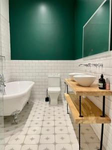 y baño con 2 lavabos, bañera y aseo. en Capel Salem By Birch Stays en Blaenau-Ffestiniog