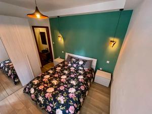 een slaapkamer met een bed en een groene muur bij Airport Accommodation Deluxe Bedroom and Private Bathroom near Airport Self Check In and Self Check Out in Mqabba