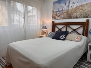 um quarto com uma cama branca e 2 almofadas em Casa del Mar em Santoña