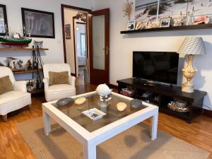 sala de estar con mesa de centro y TV en Casa del Mar, en Santoña