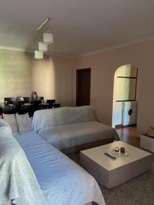a living room with two beds and a table at Mollys2apartment in Pogradec +10 photos