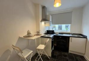 a kitchen with a counter and chairs and a stove at Minimalist 1Bed Apt near City Centre in Liverpool