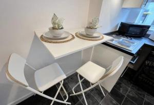 a white table with two chairs and a laptop at Minimalist 1Bed Apt near City Centre in Liverpool