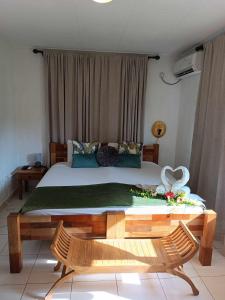 a bedroom with a bed and a table with flowers on it at Lucy's guesthouse in La Digue