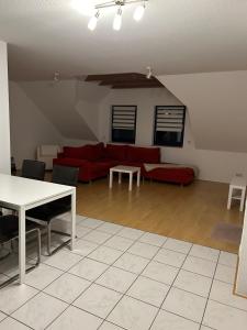 sala de estar con sofá rojo y mesa en Cute Appartement near Cologne, en Bergisch Gladbach