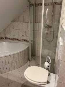 y baño con ducha, aseo y bañera. en Cute Appartement near Cologne, en Bergisch Gladbach