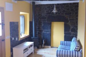 a living room with a couch and a stone fireplace at La casa'l cantirín in Pola de Lena