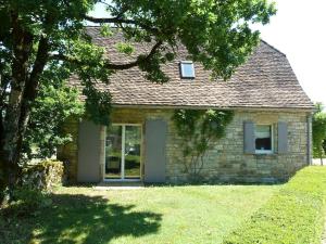 ルブレサックにあるMaison avec piscine privée à Loubressac proche Rocamadour & Vallée Dordogne, du Samedi au Samediの木の前の小さな石造りの家