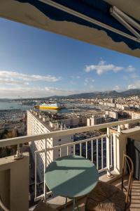 d'un balcon avec une chaise et une vue sur la ville. dans l'établissement Vue panoramique, grand appartement 2 chambres à Toulon, à Toulon