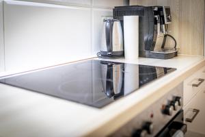 a kitchen counter with a coffee maker and paper towels at CENTRAL & AFFORDABLE by JR City Apartments in Vienna +15 photos