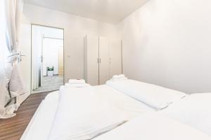 a white room with three beds and a mirror at CENTRAL & AFFORDABLE by JR City Apartments in Vienna