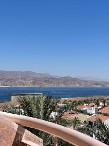 a view of the ocean from a balcony with palm trees at Luxury Exclusive Аmdar Resort with Pool Jim Near the Sea שדרות הארגמן 28 in Eilat