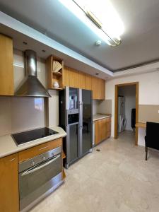 a kitchen with a stainless steel refrigerator and cabinets at Luxury Exclusive Аmdar Resort with Pool Jim Near the Sea שדרות הארגמן 28 in Eilat