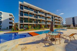 un hotel con piscina, tavolo e sedie di Flat Luxo na praia de Muro Alto - Makia Experience a Porto De Galinhas