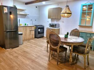 a kitchen with a table and chairs and a refrigerator at Cabañas Renova in Valdivia