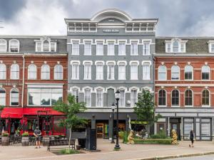 a large building with people walking in front of it at The Phenix, Historic Bldg, King Bed, Room # 305 in Bangor