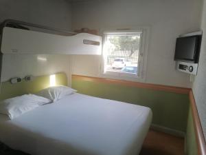 um quarto com uma cama branca e uma janela em SUN1 BLOEMFONTEIN em Bloemfontein