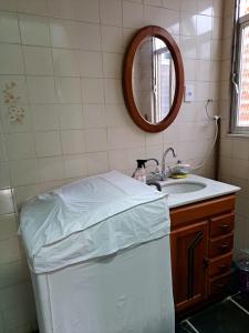 a bathroom with a bed and a sink and a mirror at Casa Costa Verde-Muriqui in Vila Muriqui +45 photos