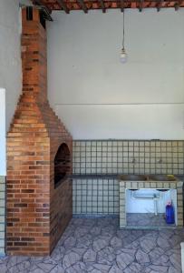 a brick oven in a room with a brick wall at Casa Costa Verde-Muriqui in Vila Muriqui