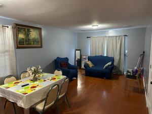 sala de estar con mesa y sillas azules en Divine Guest House Room D. 6mins near EWR NEWARK Airport, 4mins to Penn Station / Prudential, en Newark