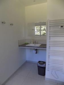 a white bathroom with a sink and a window at Gite de Pellein in Quéménéven +6 photos
