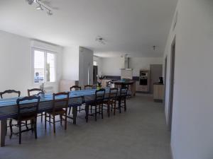 a dining room and kitchen with a long table and chairs at Gite de Pellein in Quéménéven