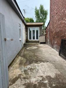 an empty driveway in front of a brick building at Entire Modern Studio Apartment with Pool Table in Denton