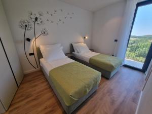 Duas camas num pequeno quarto com uma janela em Villa Lumi em Porec