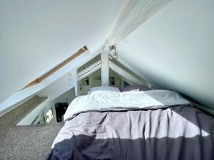 ein Schlafzimmer mit einem Bett auf einem Dachboden in der Unterkunft Magnifique 2 pièces Theatre de Boulogne in Boulogne-Billancourt + 1 Foto