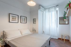 a white bedroom with a bed and a window at Giulia Apartment in Trastevere in Rome
