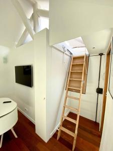 Zimmer mit einer Leiter und einem TV sowie einem Zimmer mit einer Leiter in der Unterkunft Magnifique 2 pièces Theatre de Boulogne in Boulogne-Billancourt