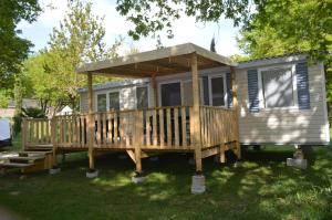 a tiny house with a porch and a deck at mobil home in Sainte-Reine-de-Bretagne