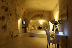 um quarto com uma cama numa parede de pedra em Caveoso Hotel em Matera