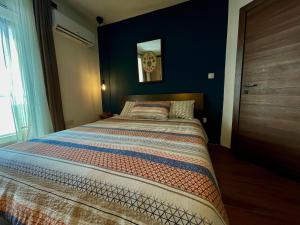 1 cama en un dormitorio con una pared azul en Airport Accommodation Bedroom with your own private Bathroom Self Check In and Self Check Out Air-condition Included en Mqabba