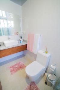 a bathroom with a white toilet and a sink at Una Estadía Vip in Santiago de los Caballeros