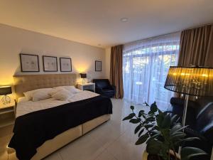 a bedroom with a bed and a chair and a window at Aparthotel Gaja in Bled