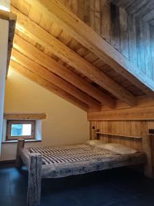 een bed in een kamer met een houten plafond bij Brand new duplex in the Dolomites - Lupo Bianco in Rocca Pietore