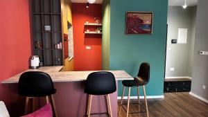 a colorful kitchen with black stools at a counter at Blini Exclusive 2 in Prishtinë
