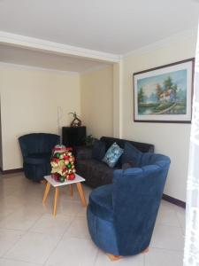 a living room with two blue chairs and a couch at Casa de Ensueño en Filandia: Tu Hogar Lejos de Casa in Filandia