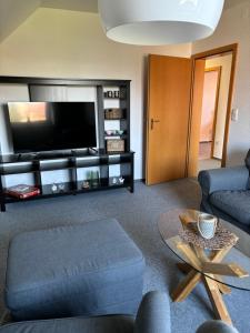 a living room with a couch and a tv at Wohnung "Strandturm" in Wremen am Deich in Wremen