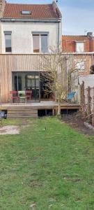 ein Haus mit einer Holzterrasse im Hof in der Unterkunft Maison avec jardin à Lille Bois Blancs in Lille