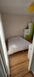 - une petite chambre avec un lit et une commode dans l'établissement Maison avec jardin à Lille Bois Blancs, à Lille