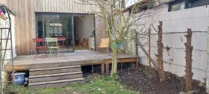une terrasse couverte en bois avec une table et des chaises. dans l'établissement Maison avec jardin à Lille Bois Blancs, à Lille 5 autres photos