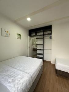 a bedroom with two beds and a closet at HOSTELFC CORFERIAS in Bogotá