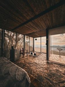 1 dormitorio con cama y vistas al océano en GLAMPING ENTRE MONTES Y CAFETALES, en Santuario