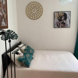 a white bed in a room with a lamp at La Villa d'Elyas in Sainte-Suzanne