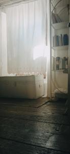 uma janela com uma cortina branca num quarto em A s'antiga em Seùlo