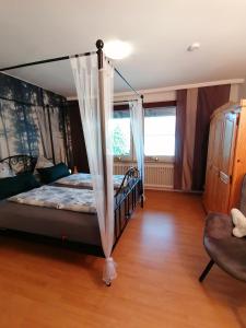 1 dormitorio con 1 cama con dosel en Ferienwohnung am Reinhardswald -Buchenzweig-, en Trendelburg